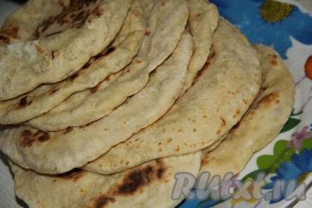 Переложить пышную лепёшку со сковороды на тарелку, примерно, через минуту она опадёт - это нормально. Аналогично раскатать и пожарить остальные лепёшки.