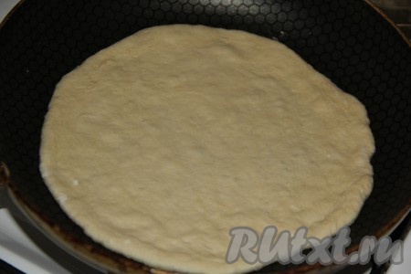 Сухую (без масла) сковороду хорошо разогреть, огонь уменьшить до среднего, выложить лепёшку, замешанную на кефире и дрожжах.