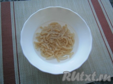 Влить воду, немного размешать макароны.
