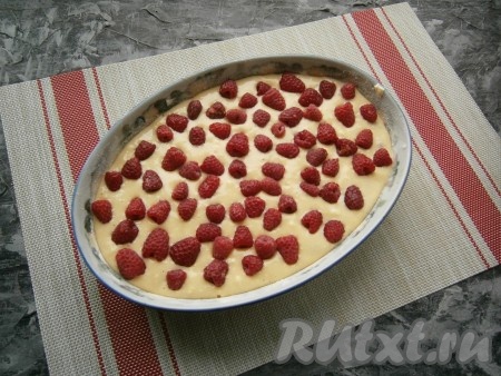 Далее выложить оставшееся тесто, разровнять его и выложить вторую часть ягод малины.
