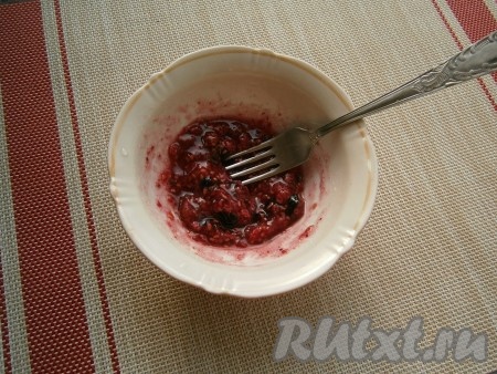 Ягоды малины и чёрной смородины размять вилкой и перемешать с сахаром.
