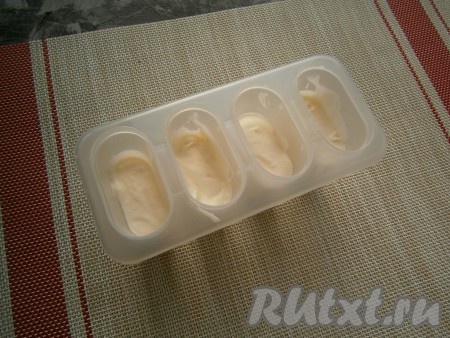 Домашнее мороженое из сметаны и ягод лучше замораживать в специальных формочках для мороженого. Разместить сметанную массу до половины объёма формочек для мороженого.
