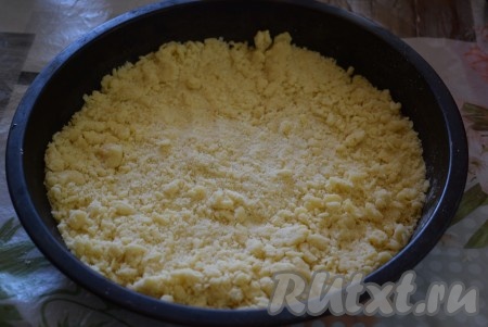 Остывшее тесто достаём из холодильника. Разделяем на 2 неравные части: большая часть теста станет основой для пирога, а меньшая - посыпкой. На дно формы диаметром 28 см выкладываем фольгу (или пергамент) и распределяем по форме большую часть теста-крошки.
