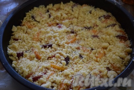 Присыпаем фрукты 1-2 столовыми ложками сахара, поверх начинки распределяем оставшееся тесто-крошку.
