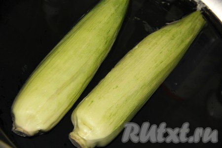 Початки кукурузы, не очищая от листвы, замочить в холодной воде на 30 минут. Благодаря замачиванию в воде, кукуруза в дальнейшем не сгорит в процессе жарки на мангале и останется сочной.
