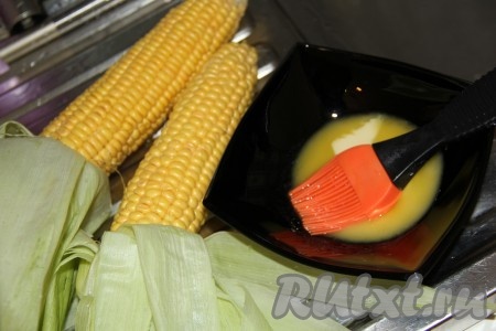 Достать кукурузу из воды и аккуратно развернуть листочки, не отрывая их (как на фото). Сливочное масло растопить.&nbsp;
