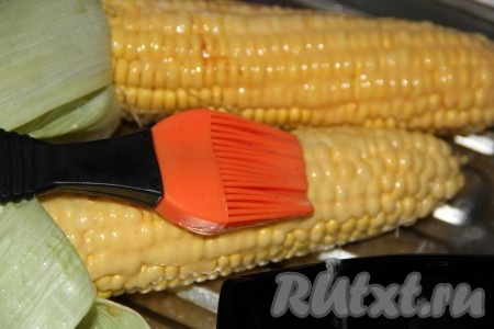 С помощью силиконовой кисти смазать кукурузу со всех сторон растопленным сливочным маслом.
