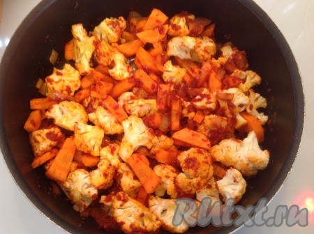 Моем, чистим и режем морковь, добавляем её к цветной капусте, перемешиваем, накрываем крышкой и тушим 5-7 минут на небольшом огне, иногда перемешивая.
