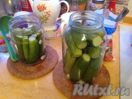 Теперь постепенно при помощи половника заливаем наши огурцы в банке маринадом, распределяя по 2 лавровых листа и 5-6 перчинок на банку.