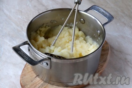 Снова перемешать толкушкой. Продолжайте перемешивать и разминать картошку толкушкой до тех пор, пока пюре не станет однородным, без комочков
