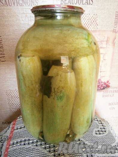 По прошествии 20 минут воду из банки слить в раковину и снова залить кабачки кипятком на 15 минут. В это время поставить на огонь кастрюлю с 1,5 литрами воды, довести её до кипения, добавить соль, лавровые листья, сахар, горчицу в зёрнах, горошины душистого и чёрного перцев, дать закипеть, уменьшить огонь до среднего и проварить 3-4 минуты, после чего влить уксус, снять кипящий маринад с огня. Воду из банки снова слить в раковину и сразу же влить в банку с кабачками кипящий маринад, полностью заполняя баночку.
