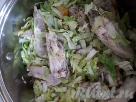 Добавить капусту к куриным крылышкам, перемешать и тушить на небольшом огне.
