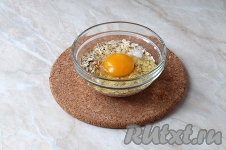 К овсяным хлопьям добавить щепотку соли, куриное яйцо и чистую фильтрованную воду.&nbsp;
