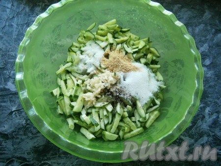 К нарезанным огурцам добавить пропущенный через пресс чеснок, всыпать соль, сахар, сухую горчицу, чёрный молотый перец, влить растительное масло и уксус.
