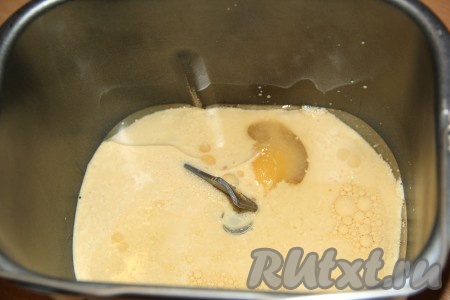 Для того чтобы замесить тесто в хлебопечке, нужно влить в ведёрко хлебопечки ряженку (или кефир) комнатной температуры, добавить растительное масло и яйцо, всыпать сахар.
