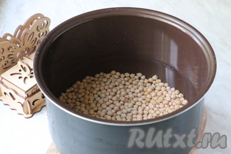 После чего воду слить, а нут тщательно промыть и выложить в чашу мультиварки. Залить 2,5 литрами горячей воды (нут заливается именно горячей водой для того, чтобы техника не тратила время на подогрев).

