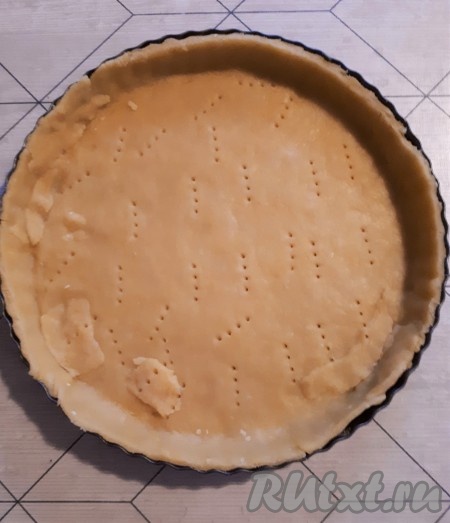 Форму для выпечки смазать маслом и присыпать мукой. Охлаждённое тесто раскатать, выложить в форму. Сформировать бортики, тесто наколоть вилкой.
