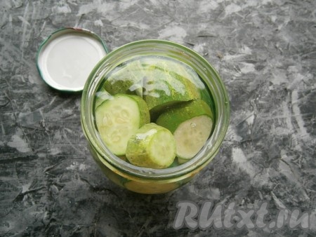 Залить огурцы кипятком, накрыть прокипячённой крышкой и оставить на 7-8 минут.
