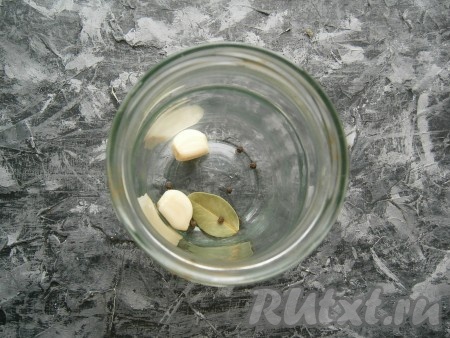 В простерилизованную сухую баночку поместить чеснок, лавровый листочек и чёрный перец горошком.
