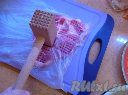 Кусочки свиной шейки промываем водой и обсушиваем бумажным полотенцем. Затем каждый кусочек кладём в пакет и отбиваем молотком для мяса с двух сторон. Можно это делать и без пакета, но я использую его, чтобы не разлетались брызги и кусочки мяса в стороны.
