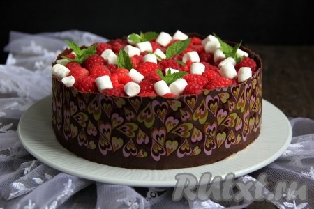 Украсить йогуртный торт с малиной по вашему желанию. Я обнесла торт шоколадным бортиком и украсила верх свежими ягодами малины и мини зефирками.
