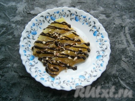 Дыню переложить на тарелку, полить сверху растопленным шоколадом и посыпать жареными измельчёнными орешками.
