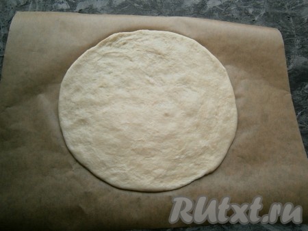 На листе пергамента охлаждённое тесто раскатать в тонкую круглую лепёшку толщиной около 0,3-0,5 см. Раскатанное тесто вместе с пергаментом переложить на противень.
