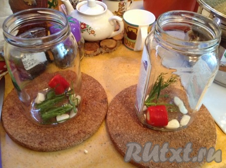 В простерилизованные банки положить нарезанный чеснок, перчик чили и укроп.
