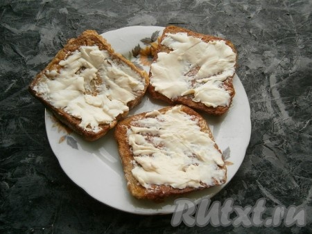 Смазать гренки мягким плавленым сыром.
