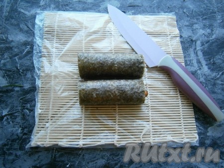 Острым, смоченным в воде ножом разрезать ролл на 2 одинаковые части.