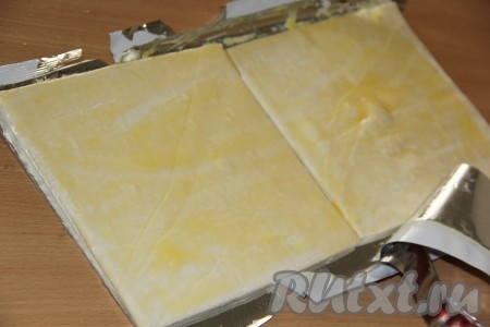 Смазать пласты теста яичным желтком.&nbsp;
