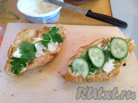 Выложить на сыр зелень и огурцы.