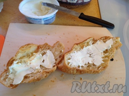 Намазать сливочный сыр на обе половинки тёплого круассана.