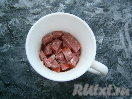 Далее выложить половину нарезанной кубиками колбасы.
