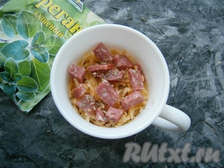 Посыпать сверху натёртым на крупной тёрке сыром и выложить оставшуюся колбасу, добавить щепотку орегано.
