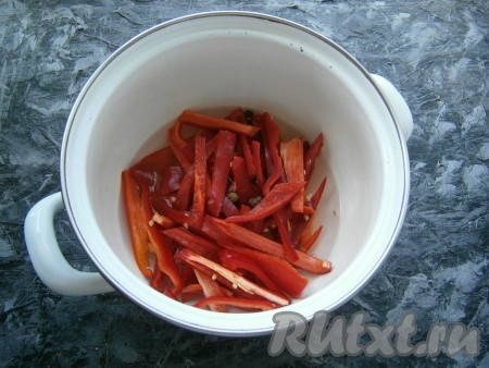 Перемешать содержимое кастрюли и довести маринад на огне до кипения. Добавить несколько горошин душистого перца. Выложить нарезанные перцы в кастрюлю с маринадом. Накрыть кастрюлю крышкой и варить перец на слабом огне 15 минут с момента закипания.