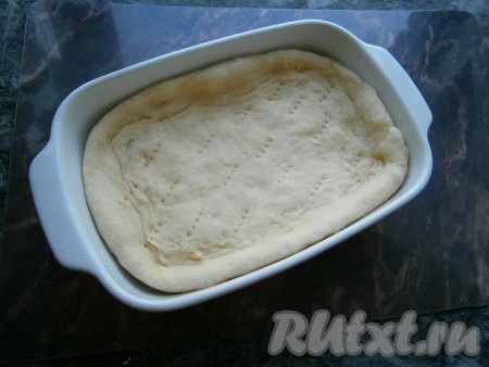 Тесто обмять, раскатать в лепёшку толщиной около 0,5-1 см. Выложить в форму, чуть смазанную растительным маслом, формируя бортики. Наколоть тесто на дне формы вилкой. У меня форма прямоугольная размером 20х16 см.
