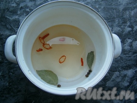 Для приготовления маринада налить воду в кастрюлю, добавить нарезанный горький перец, лавровые листья, душистый перец горошком, соль и сахар, влить растительное масло.
