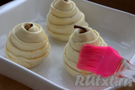 На смазанный сливочным маслом (или застеленный пергаментом) противень поместить груши в слоёном тесте. Смазать тесто слегка взбитым при помощи вилки яичным желтком. Поставить противень с грушами в разогретую духовку и запекать 25-30 минут (до золотистого цвета) при температуре 180 градусов.
