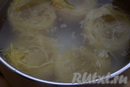 Макароны "Гнёзда" в один ряд поместить в кипящую подсоленную воду и отварить до готовности, согласно инструкции на упаковке (у меня время приготовления макарон составило 4 минуты).
