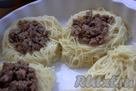 В форму для запекания (или на противень), слегка смазанный сливочным маслом, переложить аккуратно "гнёзда". В углубление каждого гнезда выложить, примерно,&nbsp;1-1,5 столовые ложки обжаренного фарша.
