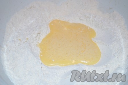 Яйцо разбить в небольшую ёмкость, слегка взбить венчиком, вылить в миску с мучной смесью.
