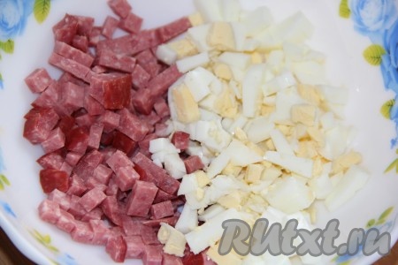 Яйцо отварить в течение 10 минут с момента закипания воды, затем остудить, очистить, мелко нарезать и выложить к колбасе.
