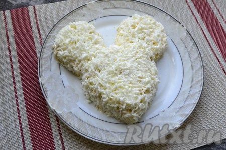 Белки также натереть на средней тёрке и покрыть ими весь салат и сверху, и с боков. Этот слой немного посолить, а майонезом не смазывать.
