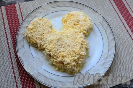 Смазать сыр немного майонезом. Варёные яйца разделить на белки и желтки. Желтки натереть и выложить следующим слоем, сверху нанести сеточку из майонеза.
