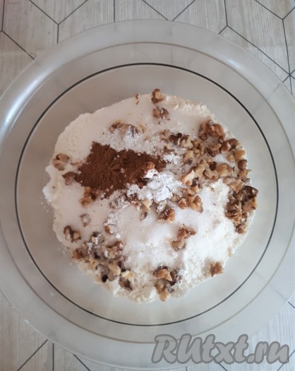 В отдельной миске соединить сухие ингредиенты (муку, сахар, ванильный сахар, разрыхлитель, соду, корицу и орехи), перемешать.
