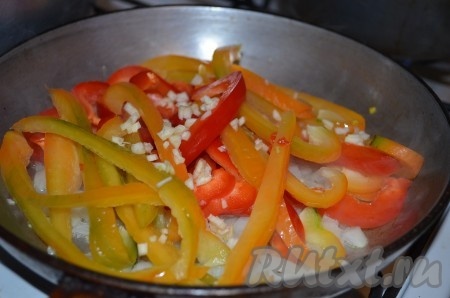 Добавить нарезанные на полоски сладкие перцы и измельченный зубчик чеснока.
