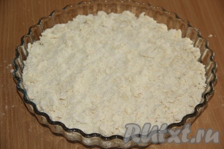 В форму для выпечки (я использовала стеклянную форму диаметром 26 сантиметров) насыпать чуть больше половины масляно-мучной крошки, равномерно распределить.