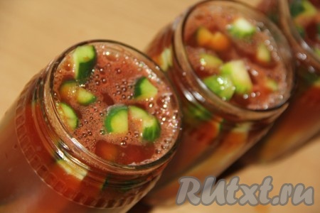 Полностью залить огурцы горячим томатным маринадом, прикрыть банки предварительно прокипячёнными крышками.
