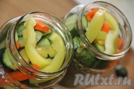 Выложить между огурцами брусочки моркови и полоски перца.
